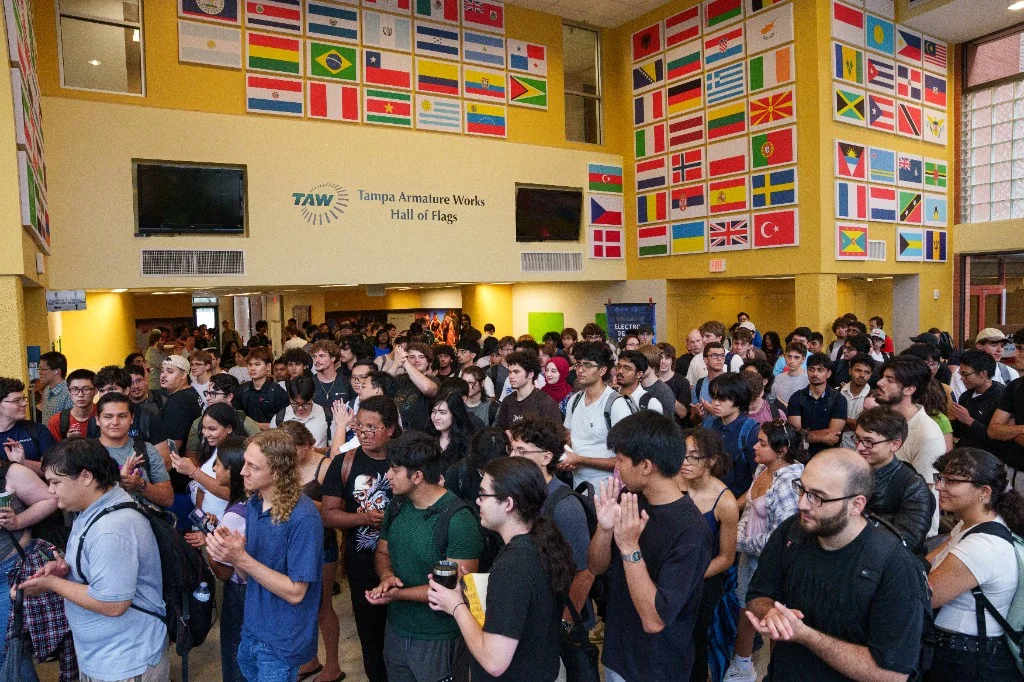 A packed Hall of Flags as students clap during the Fall General Body Meeting