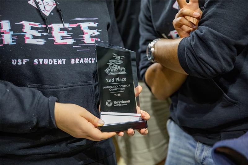 RAPTOR team member holding the second-place RTX Autonomous Vehicle Competition award