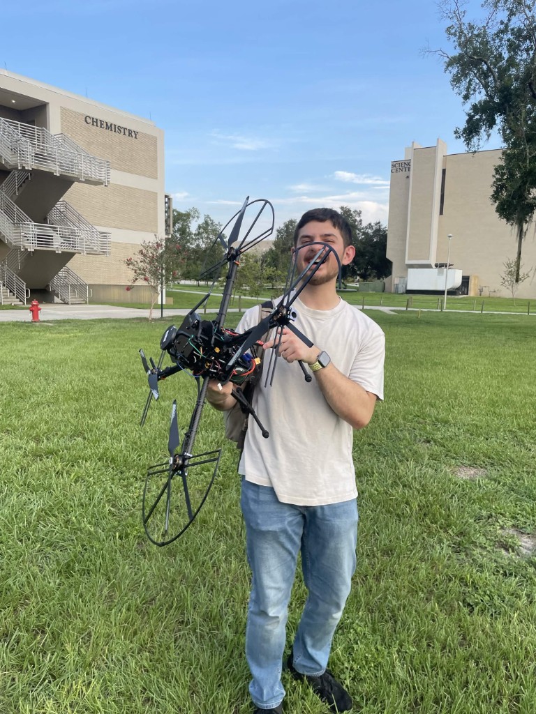 SWARM member holding a large custom-built multirotor drone on the USF campus