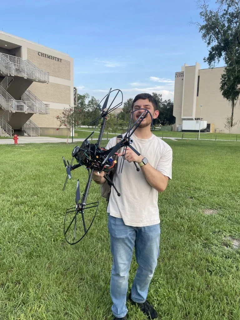 SWARM member holding a large custom-built multirotor drone on the USF campus